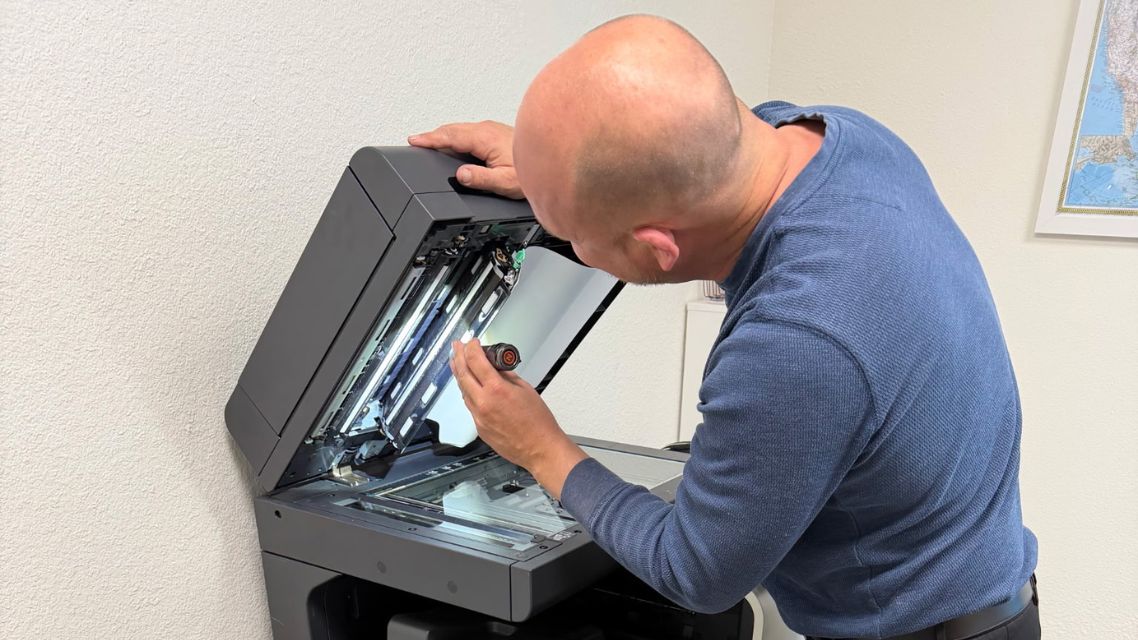 Affordable Used Copiers technician works on a copier