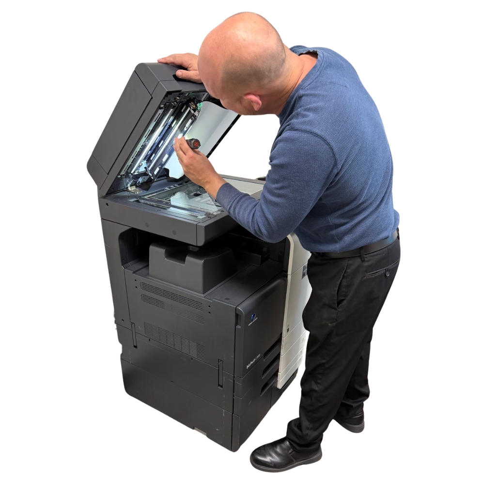 Technician at Affordable Used Copiers inspecting copier during refurbishment process in Phoenix, Arizona
